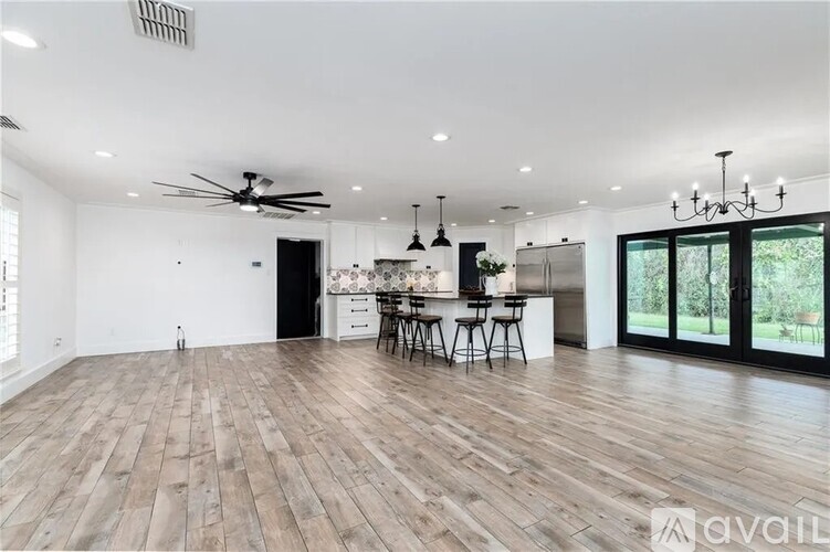 A modern open plan living and kitchen area with a bar stool.