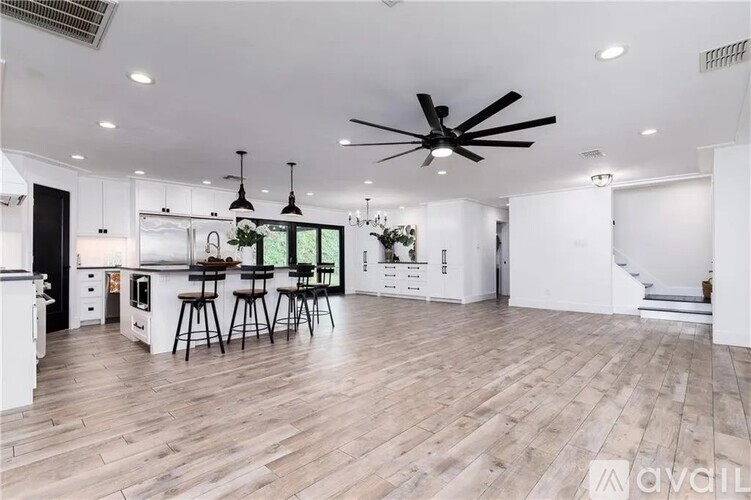 A living room with a brown couch and a ceiling fan.
