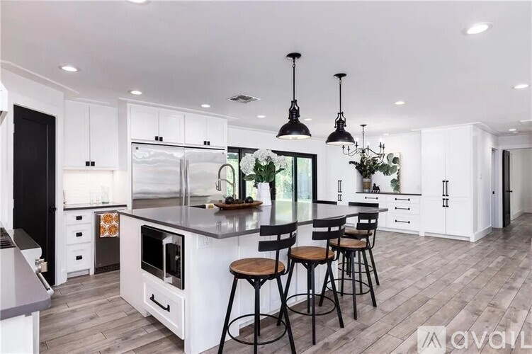 A modern kitchen with white cabinets and a large island.