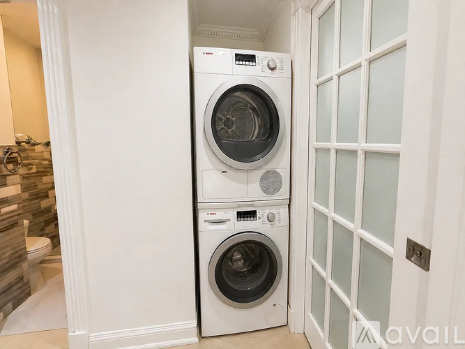 A white front loading washing machine and dryer in a laundry room.