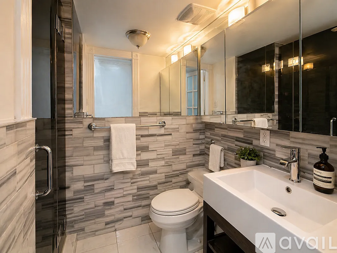 A bathroom with a white toilet, a sink, and a mirror.