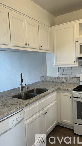 A kitchen with white cabinets and a granite countertop.