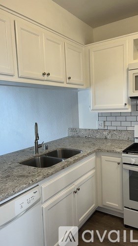 A kitchen with white cabinets and a granite countertop.