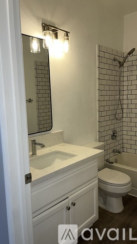 A bathroom with a toilet, sink, and shower.