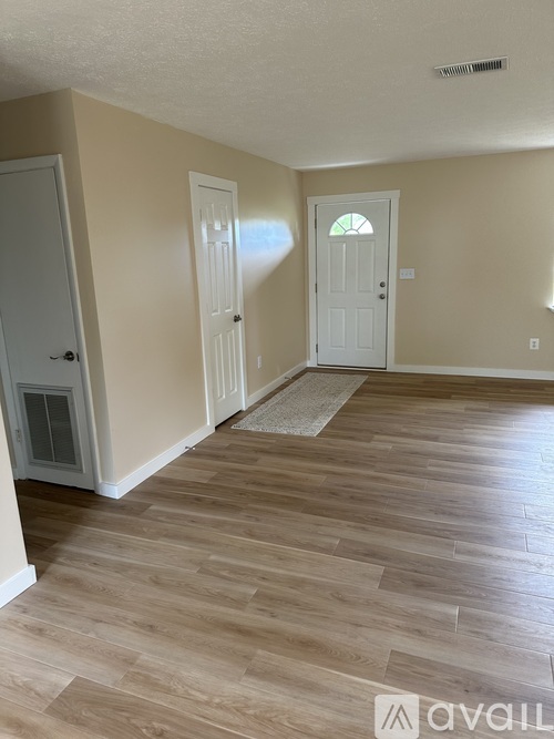 A room with wooden flooring and a white door.