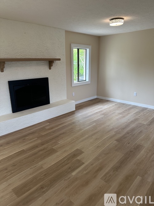 A living room with a fireplace and wooden flooring.
