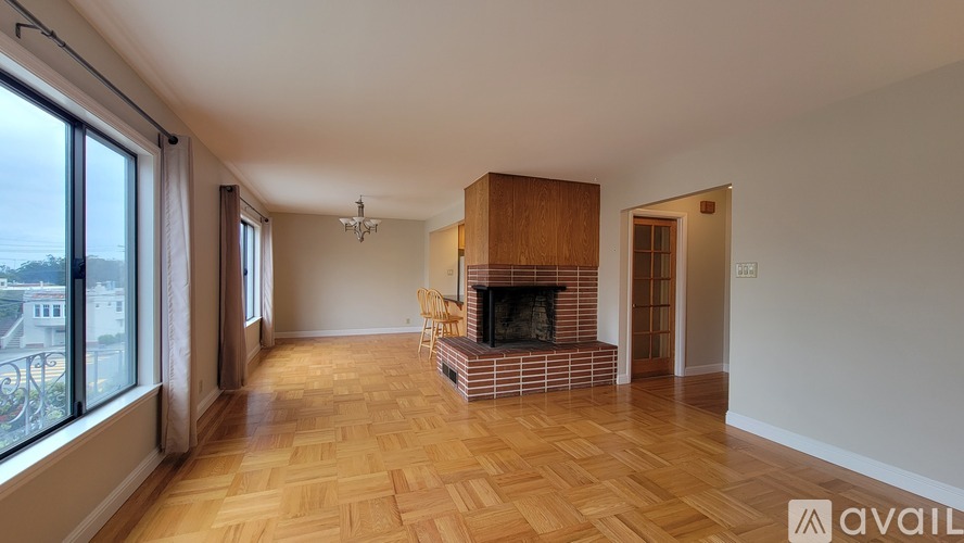 A spacious living room with a fireplace and wooden flooring.