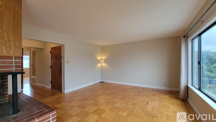 A room with wooden flooring and a large window.