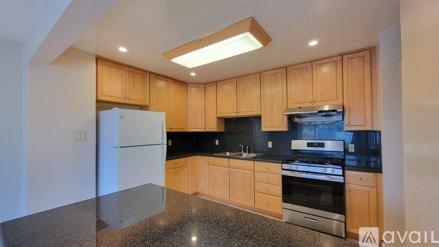 A kitchen with wooden cabinets and a black countertop.