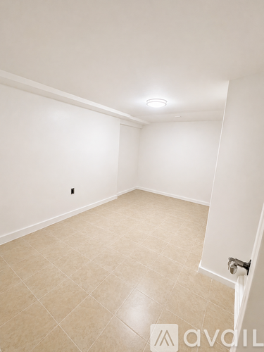 A room with beige tiled flooring and white walls.