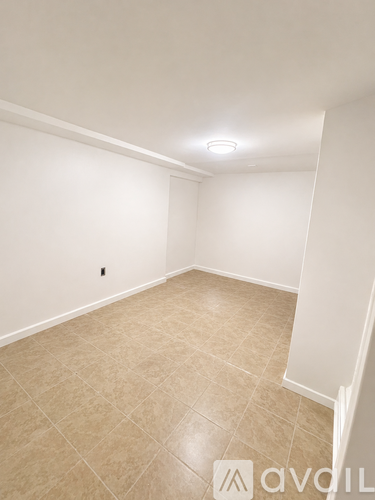 A room with beige tiled flooring and white walls.