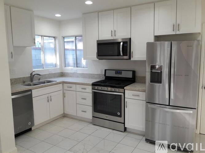 A kitchen with white cabinets and stainless steel appliances.