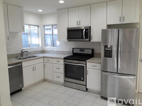 A kitchen with white cabinets and stainless steel appliances.