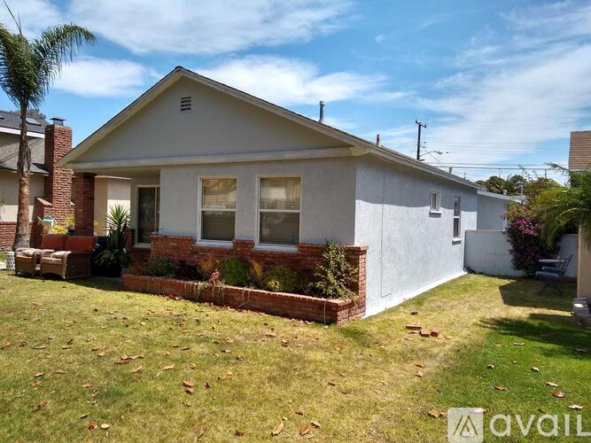 A house with a white exterior and a brick chimney is for sale.