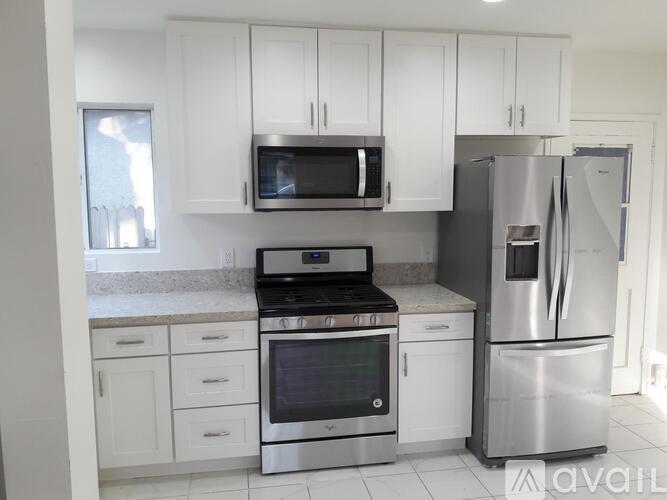 A kitchen with white cabinets and stainless steel appliances.