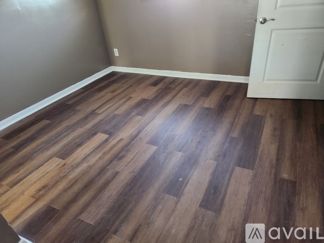 A room with a wooden floor and a white door.