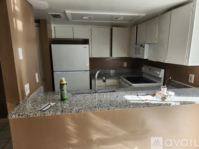 A kitchen with a granite countertop and a refrigerator.