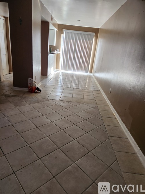 A room with a tiled floor and a door on the left.