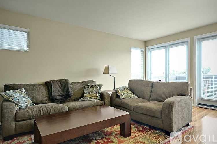 A living room with a grey couch and a brown coffee table.