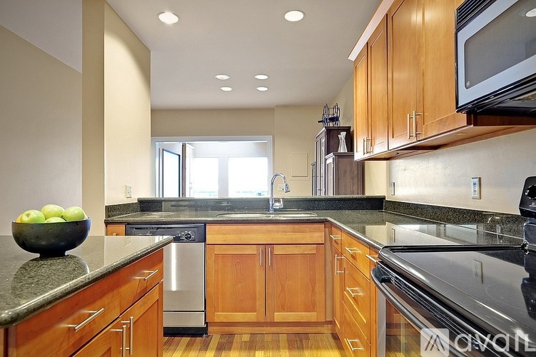 A kitchen with wooden cabinets and granite countertops.