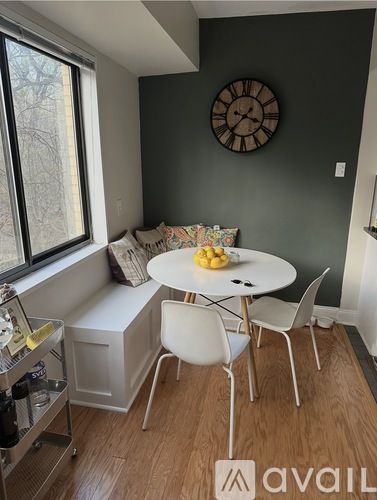 A kitchen with a table and chairs and a clock on the wall.