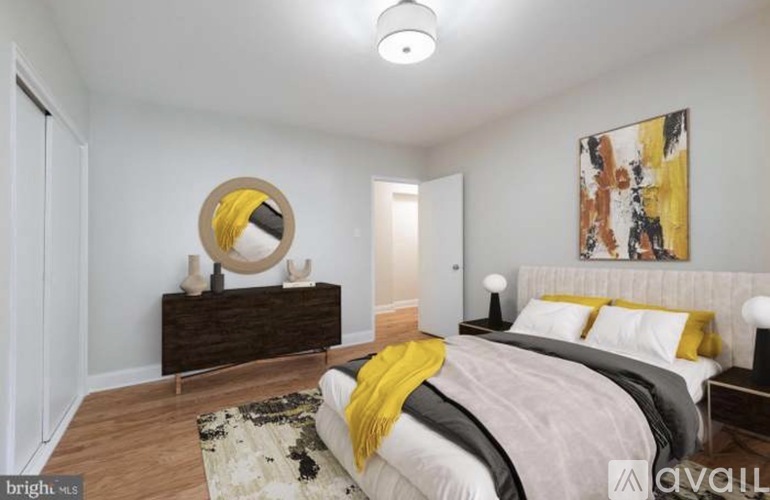 A bedroom with a bed, a dresser, and a painting on the wall.