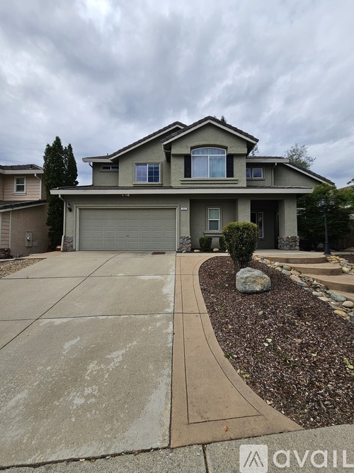 A house with a grey garage door and a driveway.