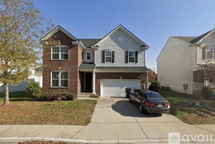 A two-story house with a garage and a car parked in front.
