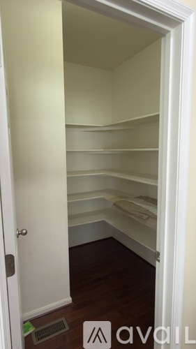 A white door is open to a room with shelves.