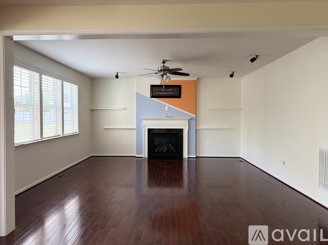 A spacious living room with hardwood floors and a fireplace.