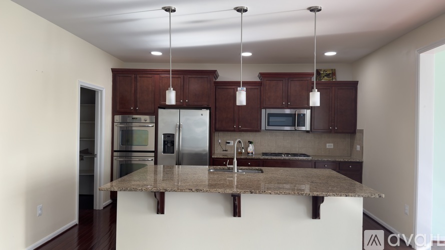 A kitchen with brown cabinets and a granite countertop.