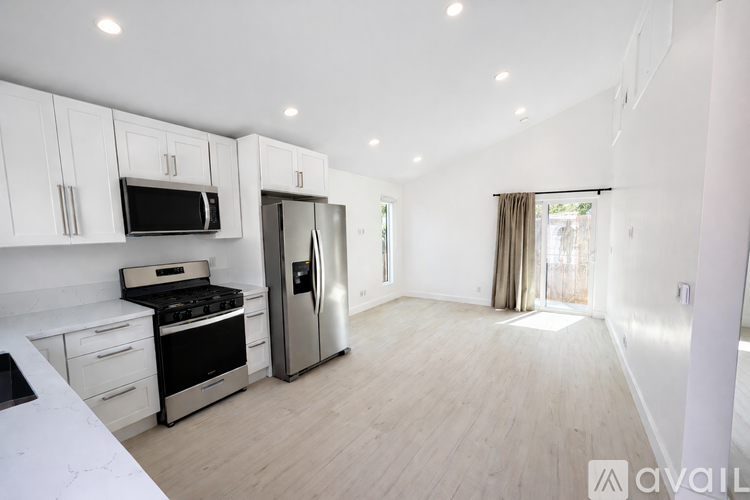 A kitchen with white cabinets and a stainless steel refrigerator.
