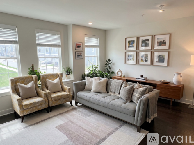 A living room with a grey couch, two armchairs, and a coffee table.