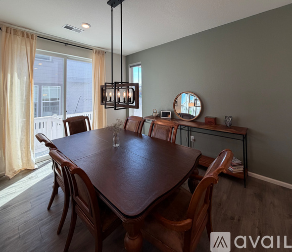 A dining room with a wooden table and chairs.
