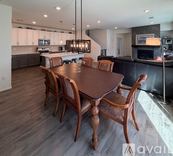A wooden dining table with chairs in a modern kitchen.