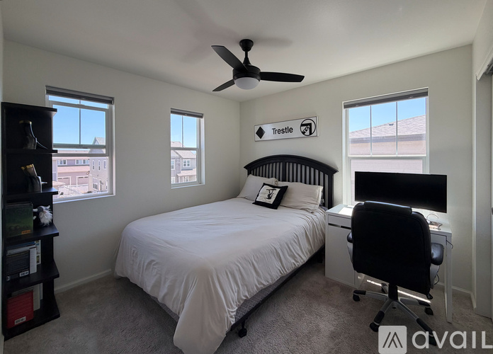 A bedroom with a bed, desk, and chair.