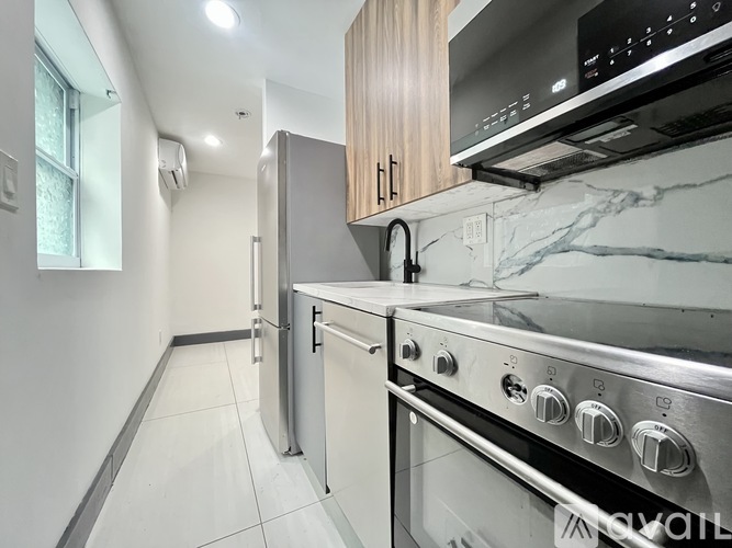 A modern kitchen with stainless steel appliances and wooden cabinets.