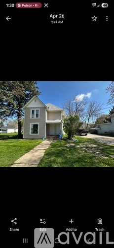 A house with a white front yard and a tree in front of it.