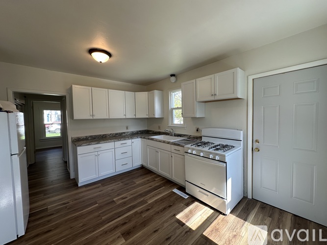 A kitchen with white appliances and cabinets.
