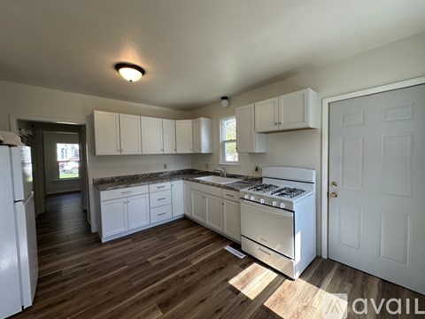 A kitchen with white appliances and cabinets.