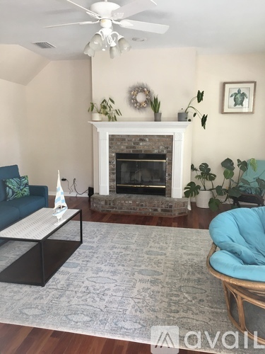 A living room with a fireplace and a blue chair.