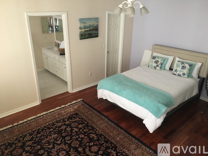 A bedroom with a bed, dresser, and mirror.