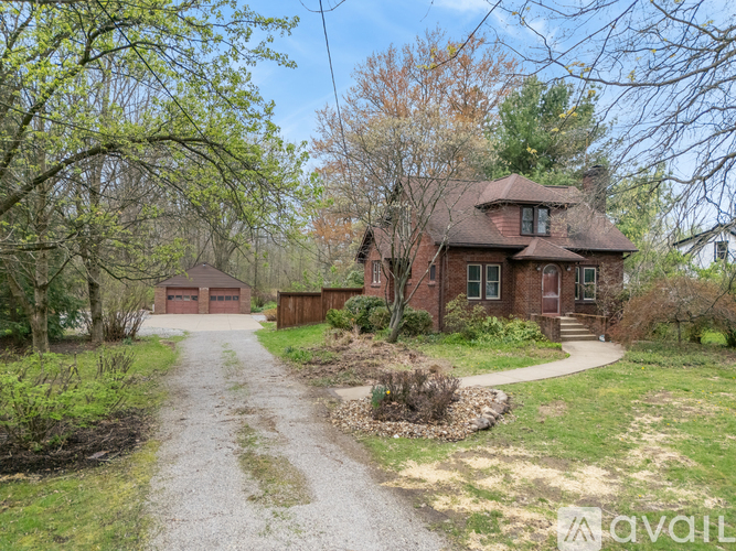 A house with a driveway and trees in the background.