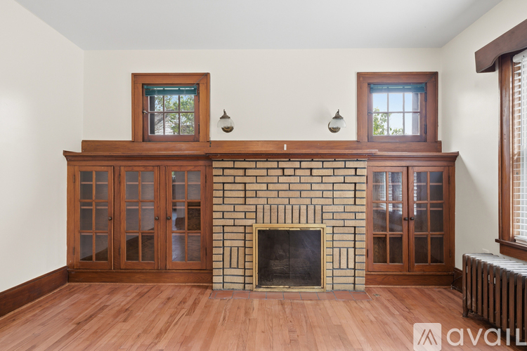 A living room with a fireplace and wood flooring.