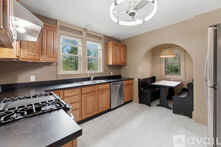 A kitchen with a black stove top oven and wooden cabinets.