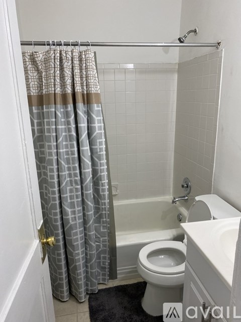 A bathroom with a toilet, a bathtub, and a shower curtain.