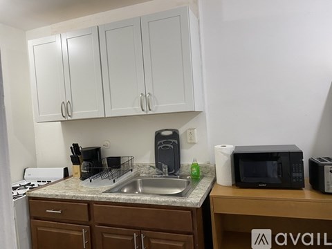 A kitchen with white cabinets and a sink.