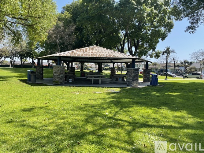 A gazebo sits in the middle of a grassy field.