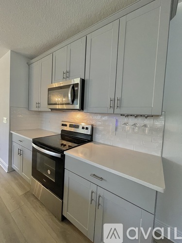 A kitchen with white cabinets and a black stove top oven.