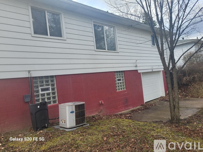 A house with a red and white exterior and a tree in front.